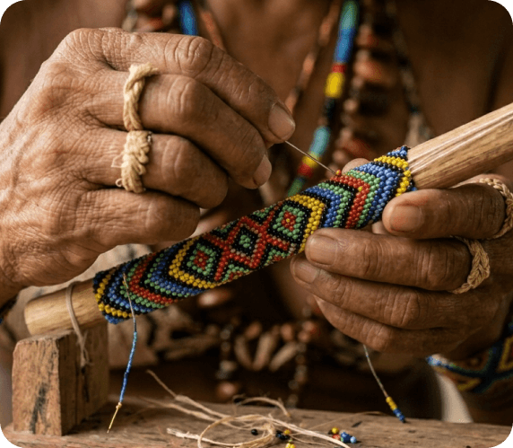 Artesã indígena trabalhando em uma peça artesanal